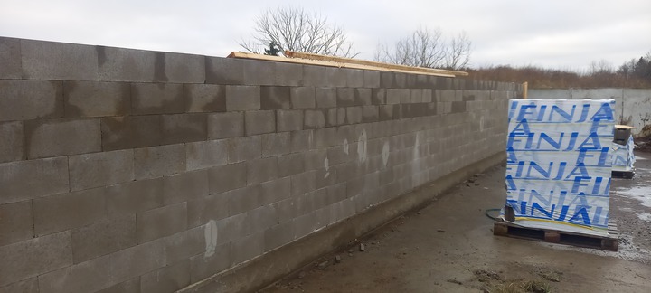 Byggarbetsplats med en nyligen uppförd mur av betongblock
