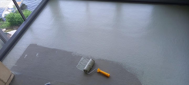 Målning av betonggolv med roller på en balkong